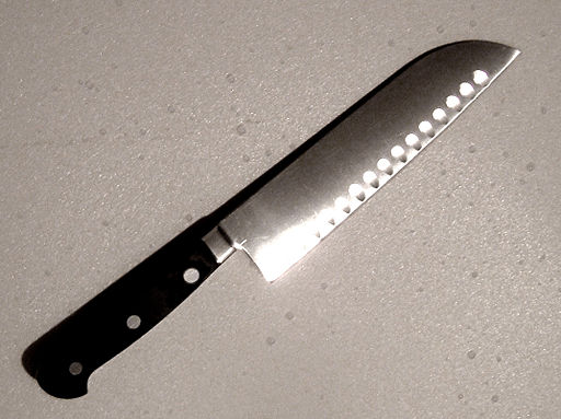 image of a Santoku knife, a medium-sized, multipurpose kitchen knife of Japanese origin that has a lightweight blade with a straight or slightly curved cutting edge and a spine that curves downward to the tip