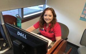 Young woman sitting at a desk behind a computer moniter