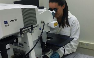 Female lab technician looking into microscope