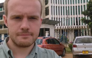 Young man standing on a street in front of a building