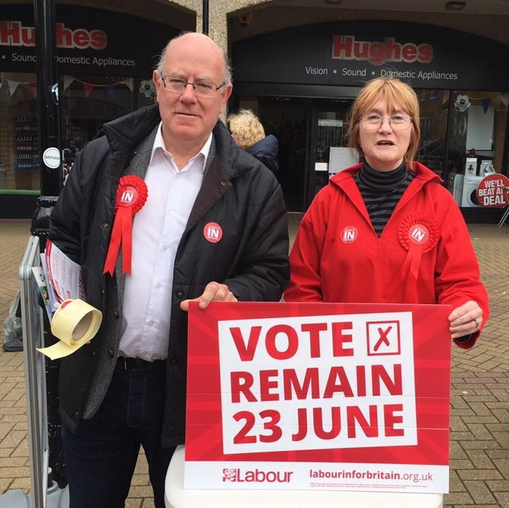 A man and woman stand behind a campaign sign urging voters to "Vote Remain 23 June".