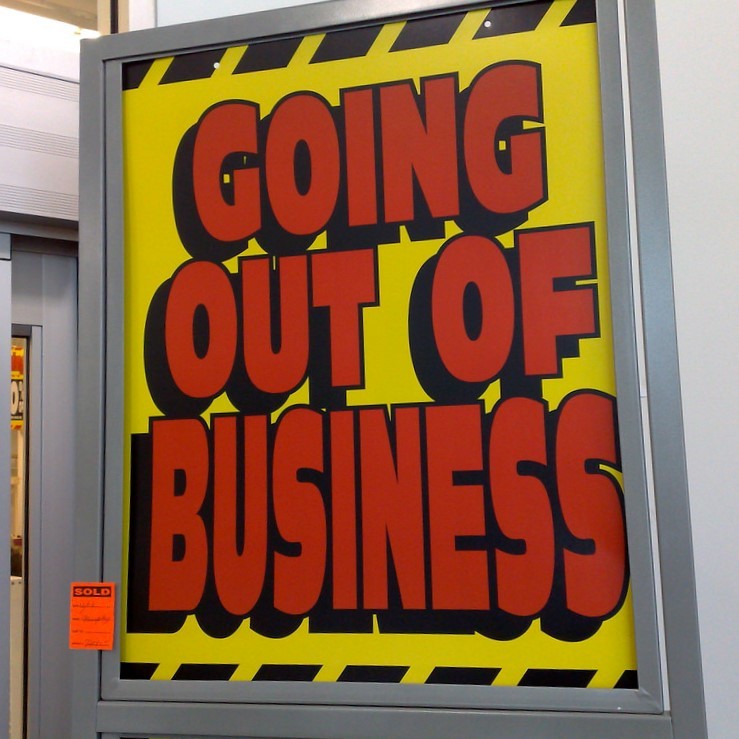 A "Going out of Business" sign is posted outside a store.