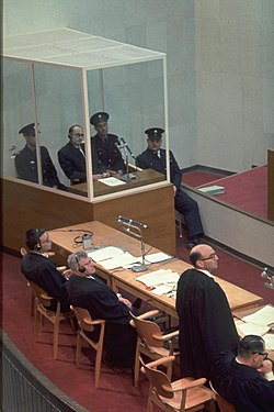 Photo of Eichman trial. Eichman sits in a glass enclosed box.