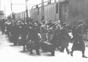 Black and white photo of men carrying suitcases to a train from the Vel d’Hiv Round-up (2)