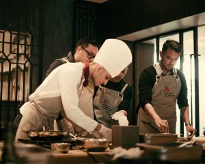 Chef and restaurant staff plating food as a team