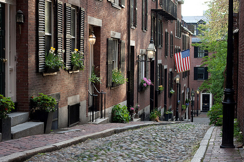 View of a cobblestone street with well maintained brick homes in Beacon Hill, Boston, MA