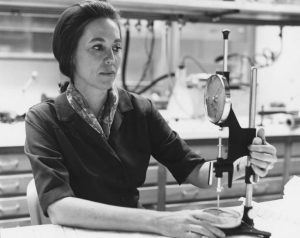 black and white image of female scientist looking at a scientific instrument in a laboratory