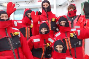 group of people in orange survival suits