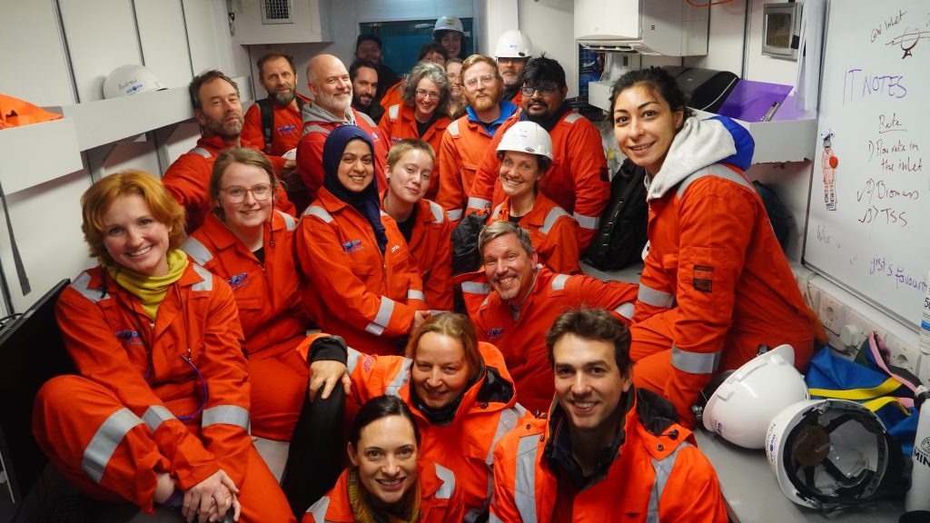 Group of people wearing work coveralls looking forward at the camera