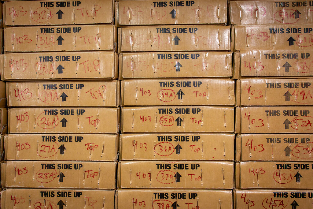 Stacked cardboard boxes that say "This side up."