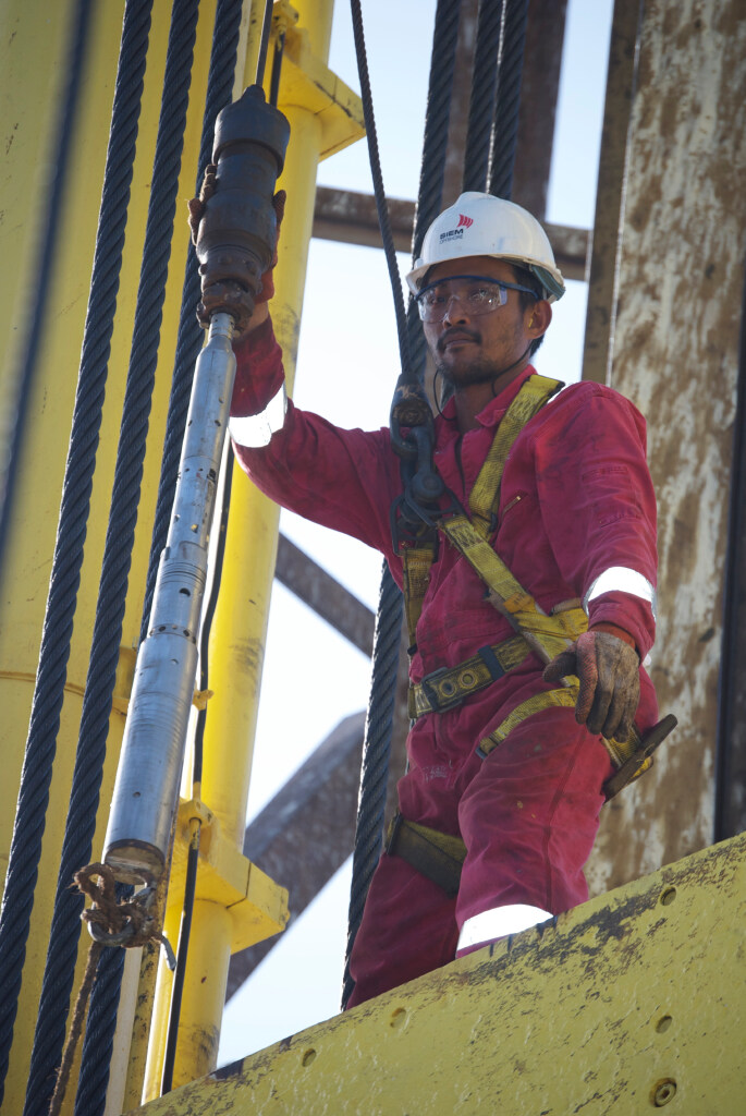 A Siem Offshore Floorman works with the downhole logging tools (Credit: Angela Slagle, IODP USIO) [Photo ID: exp340_033]