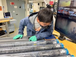 Haiyang Liu (Igneous Petrologist, Chinese Academy of Sciences, P.R. China) looks at core sections on the description table in the core lab.