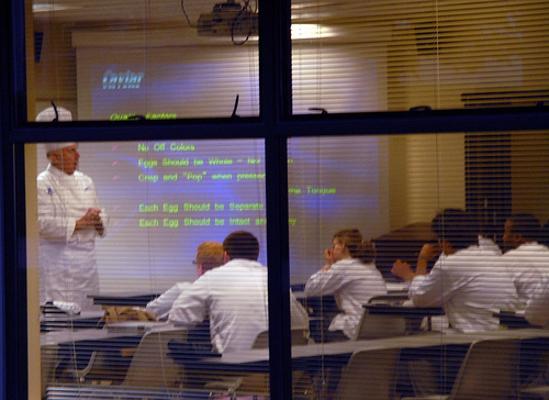 A chef teaching his class how to make Caviar, using the help of a powerpoint
